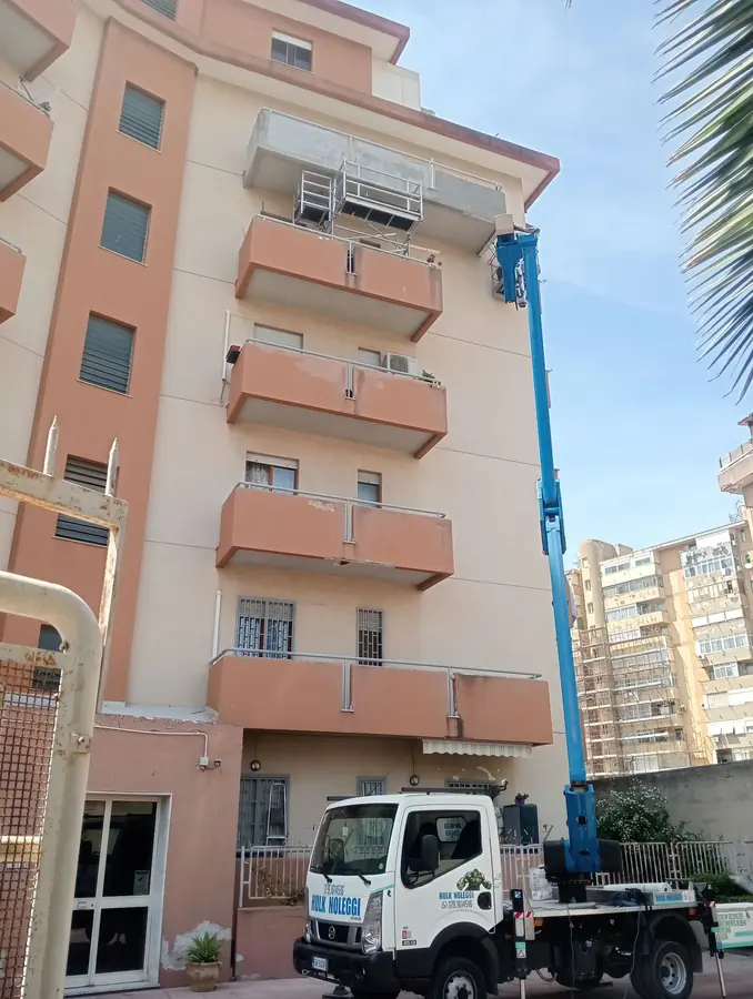 Braccio blu quasi verticale fino all'ultimo balcone di un condominio
